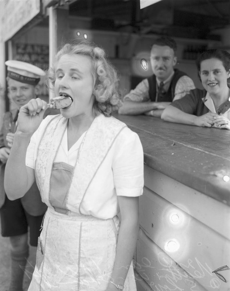 Mrs. Jean Tolcroft eating ice cream at the Brisbane Exhibition 1949. Jean Tolcroft eating ice cream at the Brisbane Exhibition 1949. John Oxley Library, State Library of Queensland. Image 28118-0001-0288