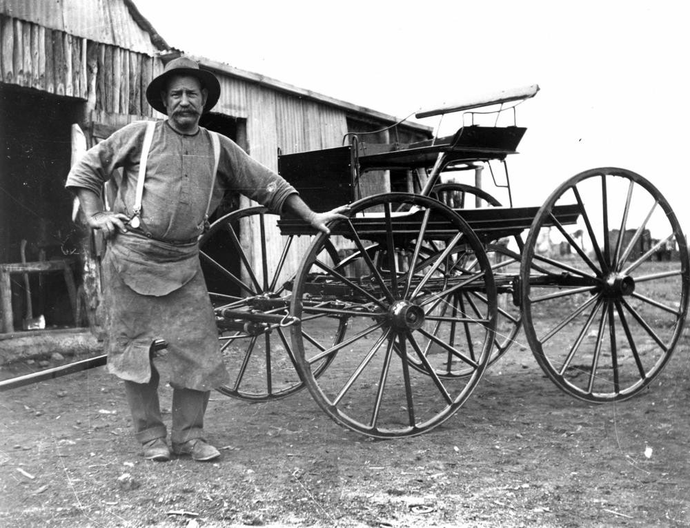 man stands in front of a handmade cart 