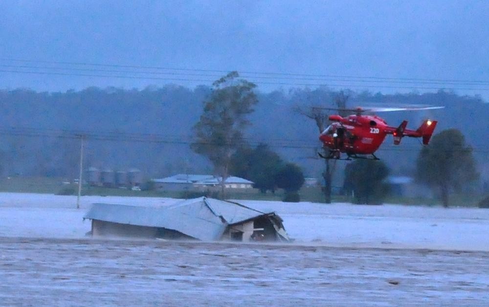 NSW Rural Fire Service helicopter flying over a collapsing house during the floods in Grantham Queensland 2011
