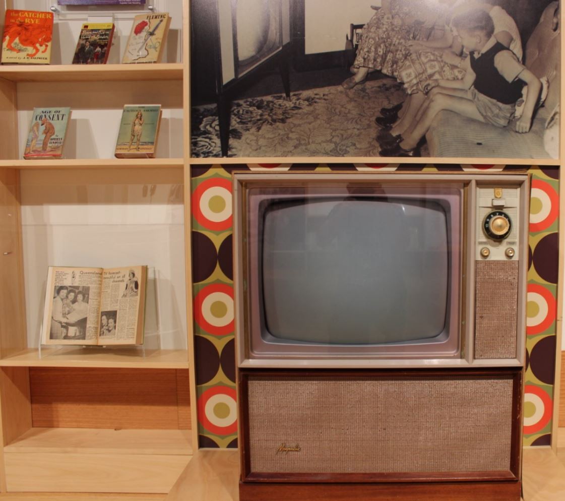 Open copy of the first edition of the TV Times Qld edition 1959 and a ca1970s television set on display as part of the Freedom Then Freedom Now exhibition in 2017