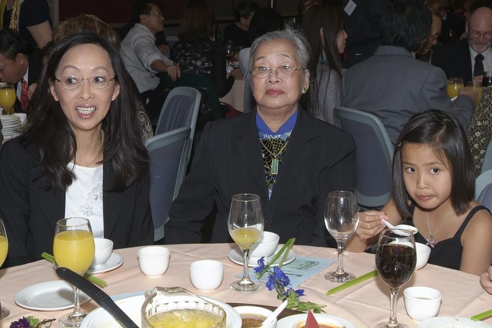 2 adults and one child sit at a dinner table