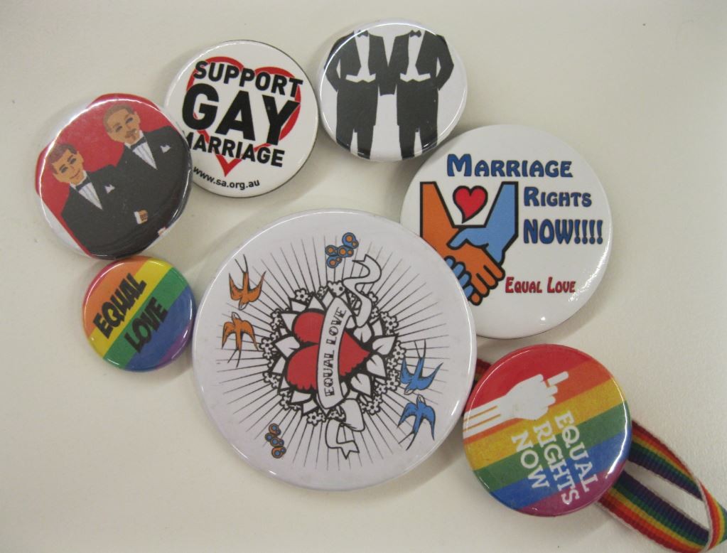 An assortment of badges from the Equal Love Brisbane collection held by State Library of Queensland