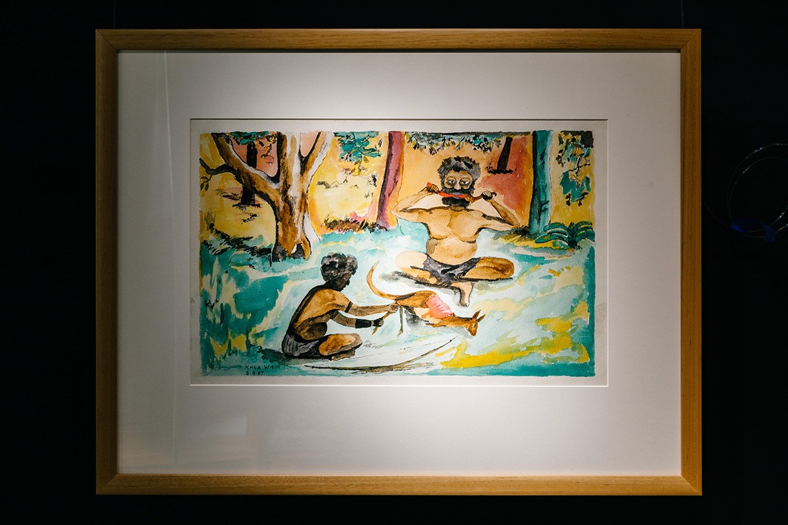 This watercolour painting by Kala Waia is entitled Baira and Agburug as man and illustrates the Torres Strait Islands legend of Agburug  The painting depicts Baira sitting cross-legged in a clearing in the bush eaing kangaroo meat with another man The dead kangaroo is in the centre of the painting 