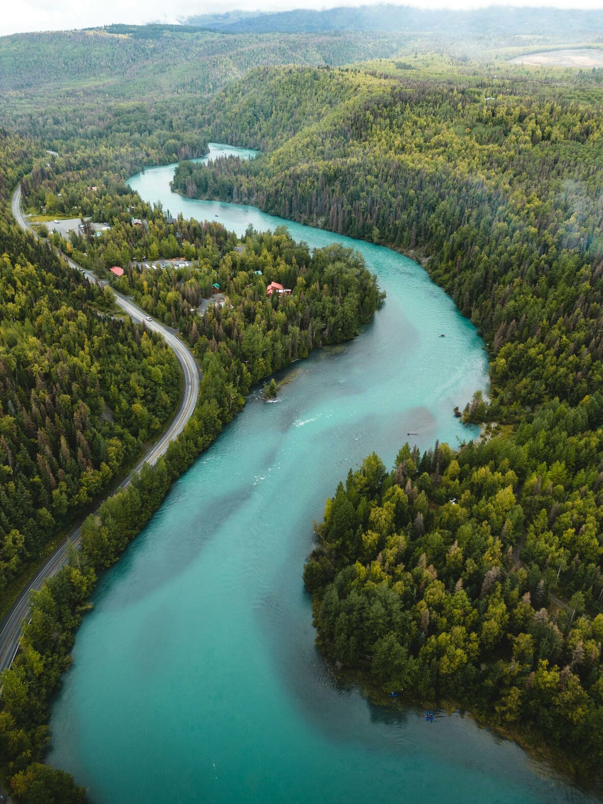 A river winds through green forests in Alaska