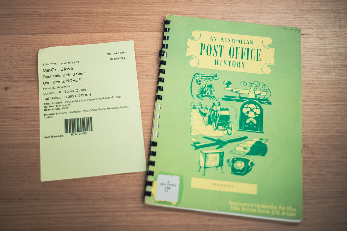 A hold slip from a library and a green, spiral bound pamphlet called "An Australian Post Office History (Innisfail)"