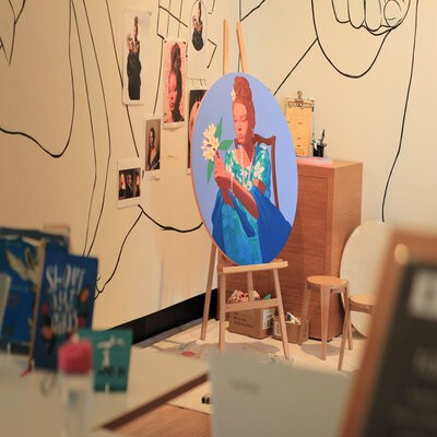 Corner of a studio at the Museum of Brisbane showing a painting on an easel