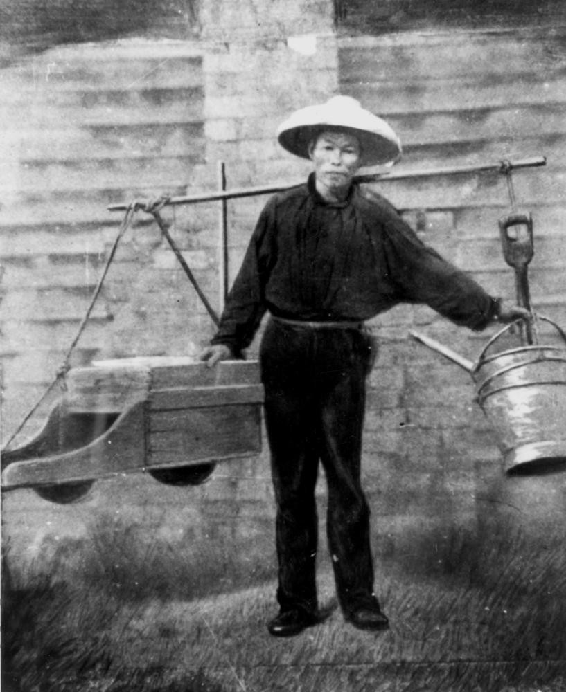 A Chinese gold digger carrying instruments on his shoulder
