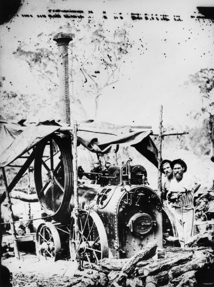 Prospectors next to a portable steam engine ca 1870