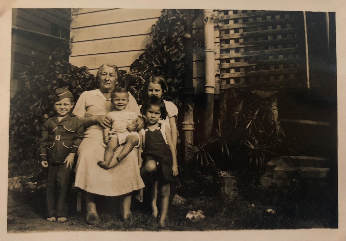 Emma Sokoll sitting in a garden with her 4 young grandchildren