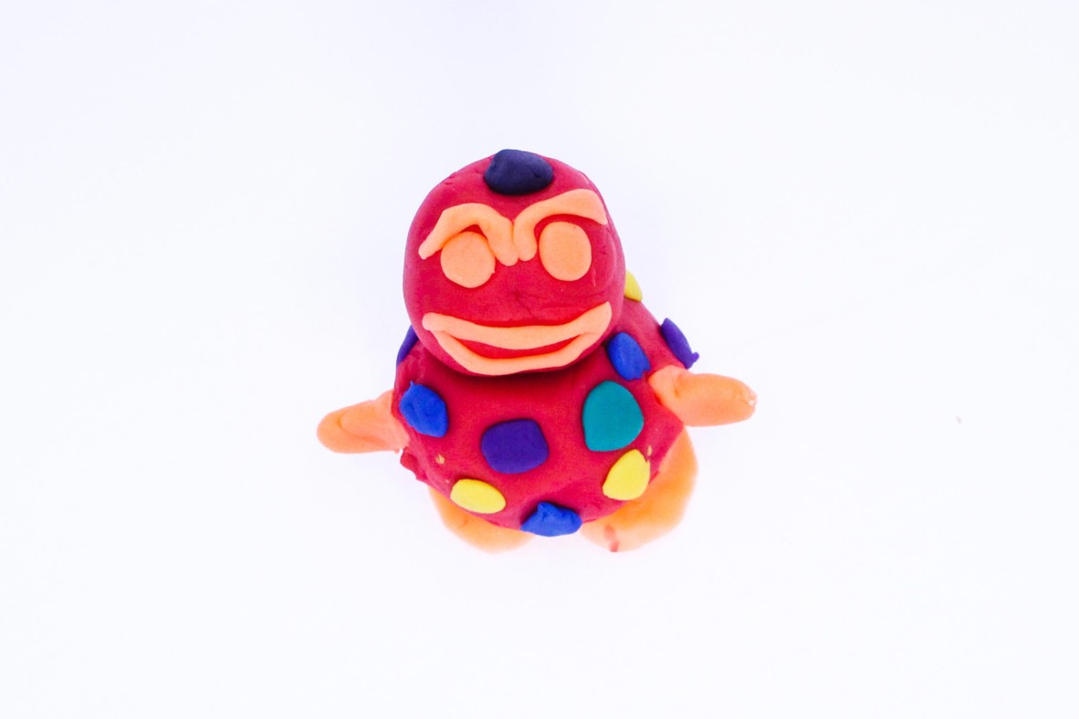 Kitty Bear is a red and purple play-dough sculpture that features whiskers and a suit