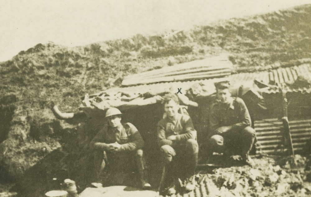 Mallyon (centre) with two comrades in a muddy dugout, France.