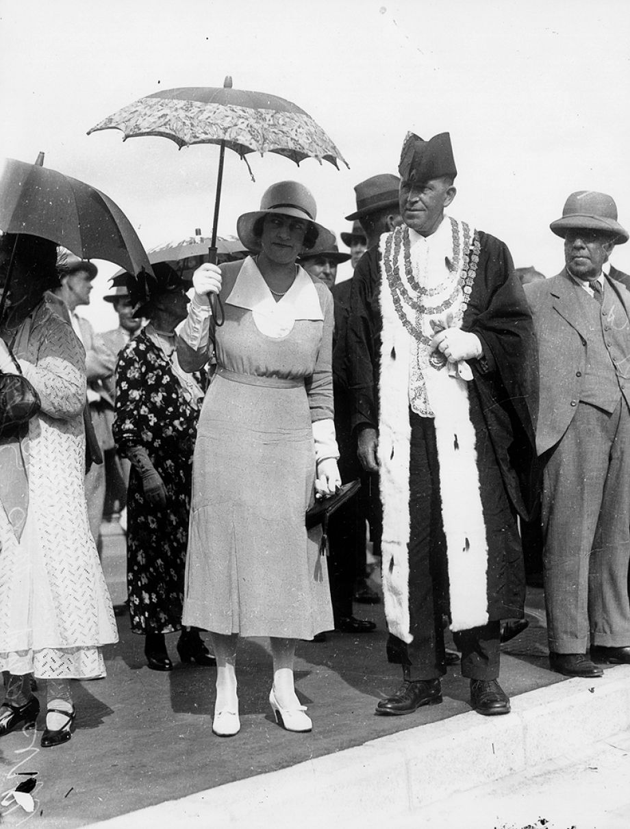 The Lord Mayor and Lady Mayoress photographed at the opening of the Bridge. They have an air of anticipation - perhaps to be collected for the car procession over the Bridge? The Brisbane Courier wrote that the Lady Mayoress wore Gothic patterned silk in two tones of delphinium blue with a deep white satin rever collar and a white fancy panama hat.’ (31 March 1932).