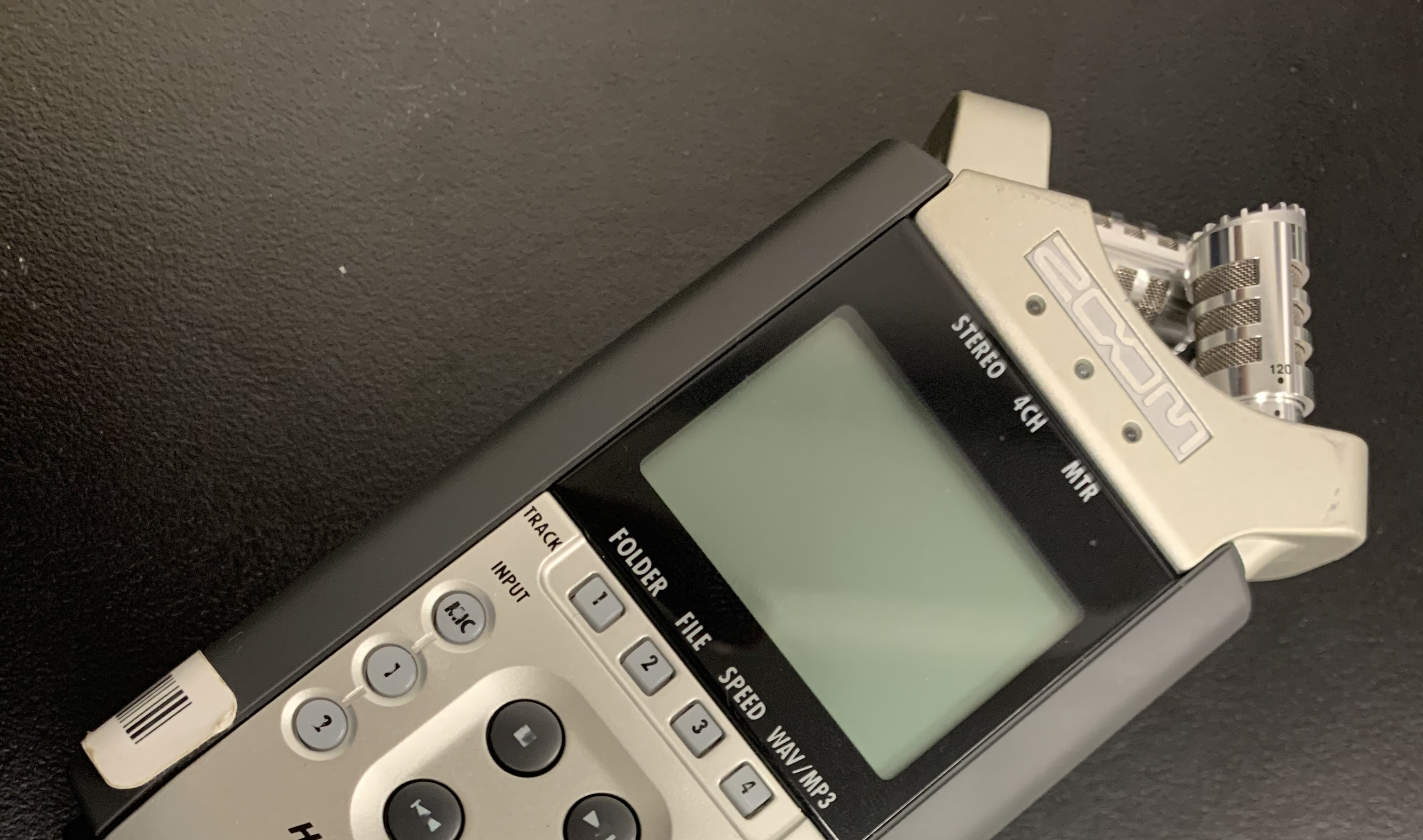 Close up crop of a Zoom audio recorder on a black tabletop